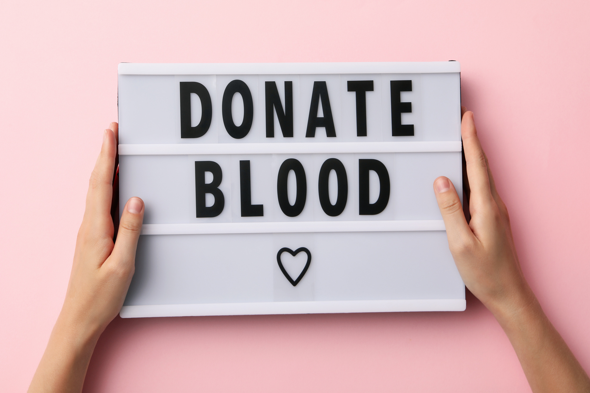 "Donate blood" poster on a pink background. Blood donation